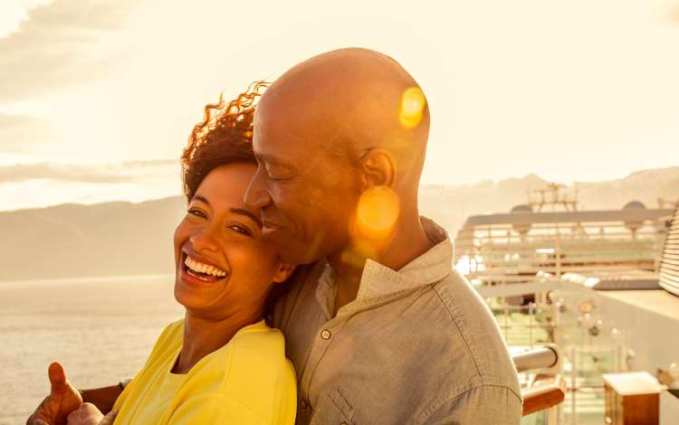 Couple stood at deck looking into sunset