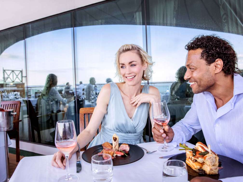 Couple enjoying dining on deck of cruise ship