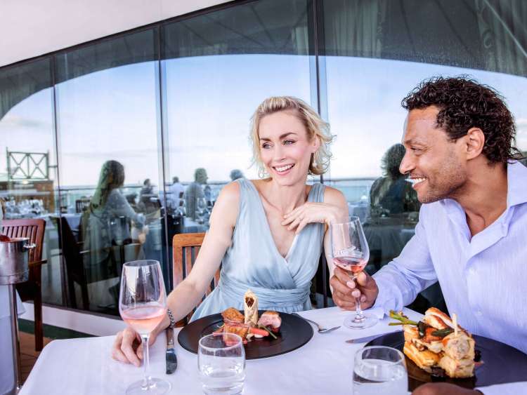 Couple enjoying dining on deck of cruise ship