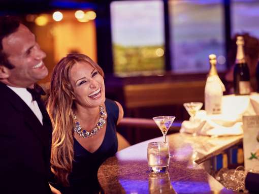 Couple dressed for formal night at the bar on-board