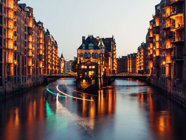 City lit up by river at night