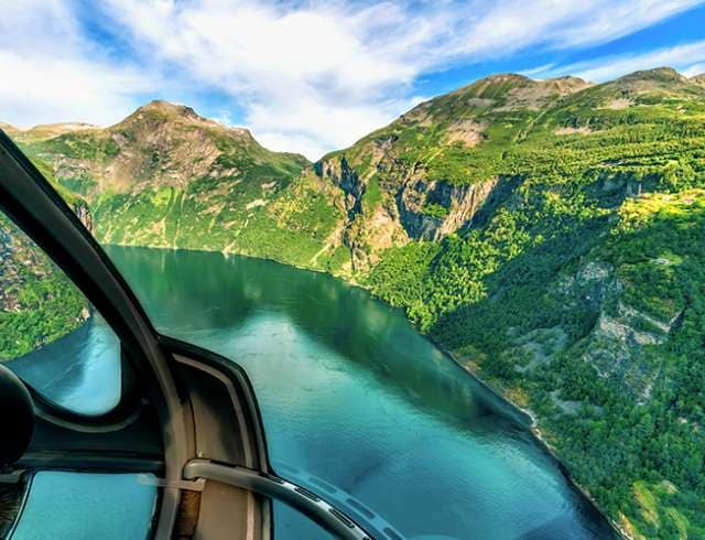 Helicopter flying over mountains in Norway