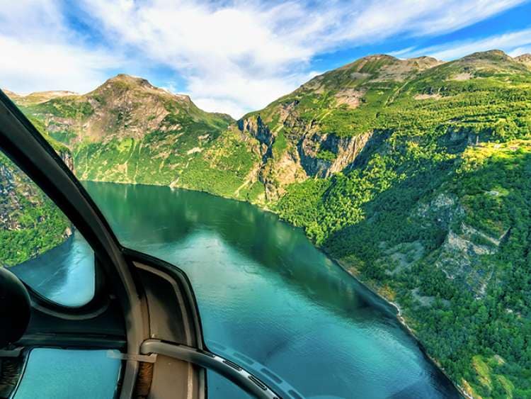 Helicopter flying over mountains in Norway