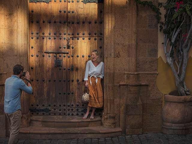 Couple taking photo near big wooden gates