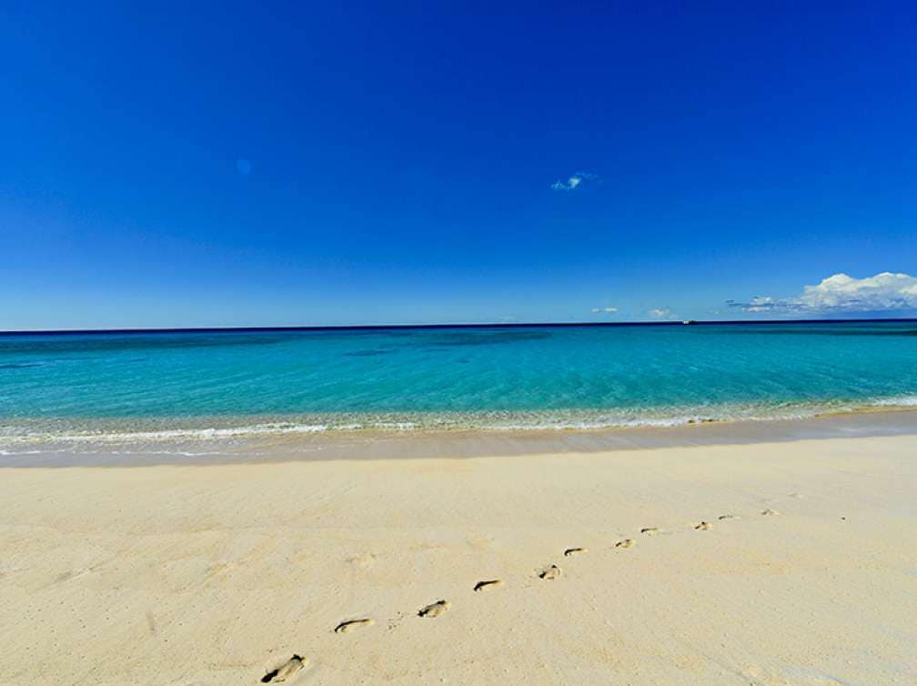 grand turk beach with footsteps on sand