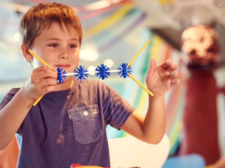Boy playing on-board children's club, The Reef