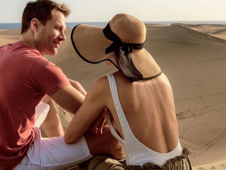 Couple chatting together on sand dunes