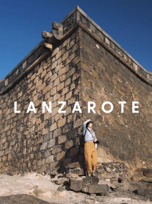 Woman standing by stone walls in Lanzarote in the Canary Islands