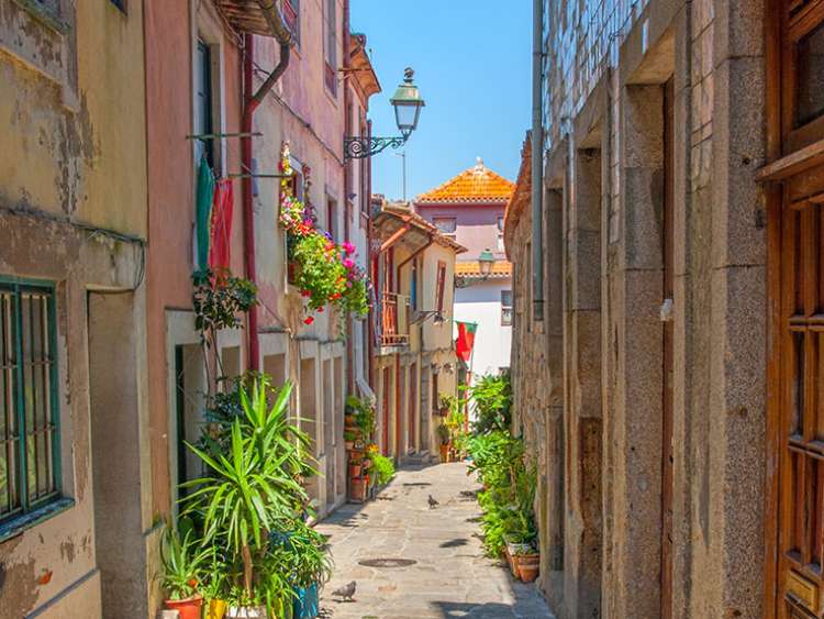 Narrow street in the old town under a bright blue sky in summertime, Porto, Portugal, Europe.