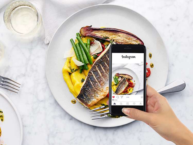 Woman putting her meal on Instagram on her phone
