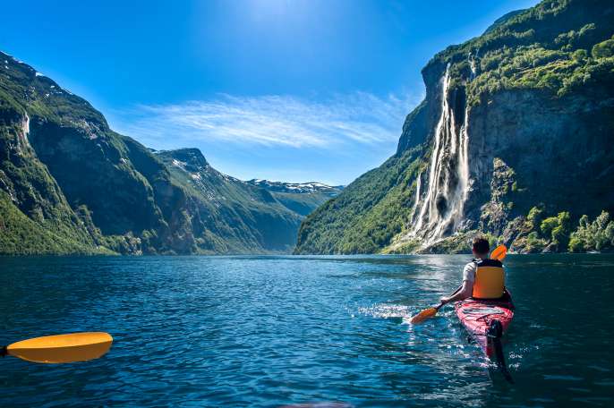 young man kayaking along the fjord geiranger enjoying the waterfall "seven sisters"; Shutterstock ID 1116256364; Client: P&O Cruises; Job: Iona 5 unforgettable moments ; Licensee: Isabella; Notes: 