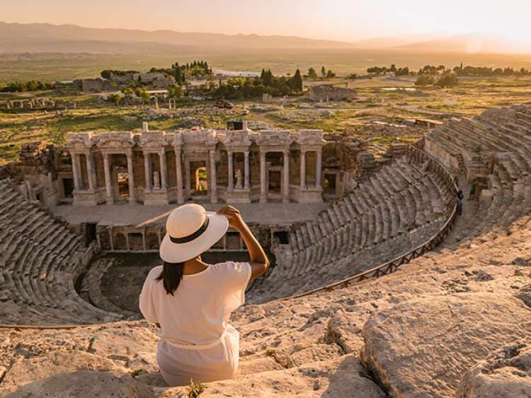 Woman sat on stone seating looking at view