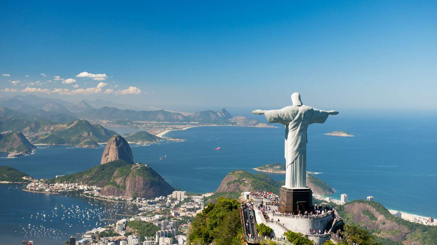 Aerial view of 'Christ The Redeemer' statue with Sugarloaf Mountain, Copacabana Beach and Botafogo Beach in the background.