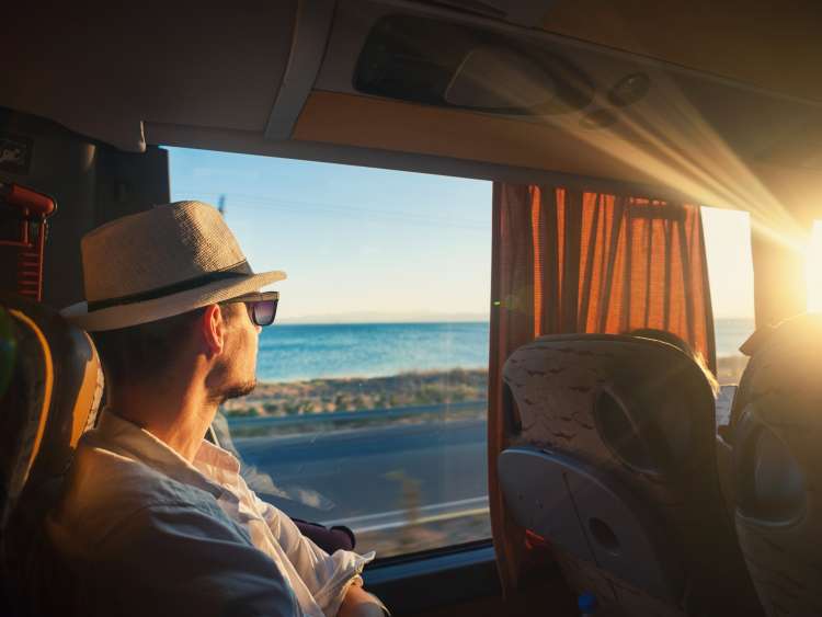 A man is traveling and looking through the bus window during the covid19 corona virus  pandemic	
