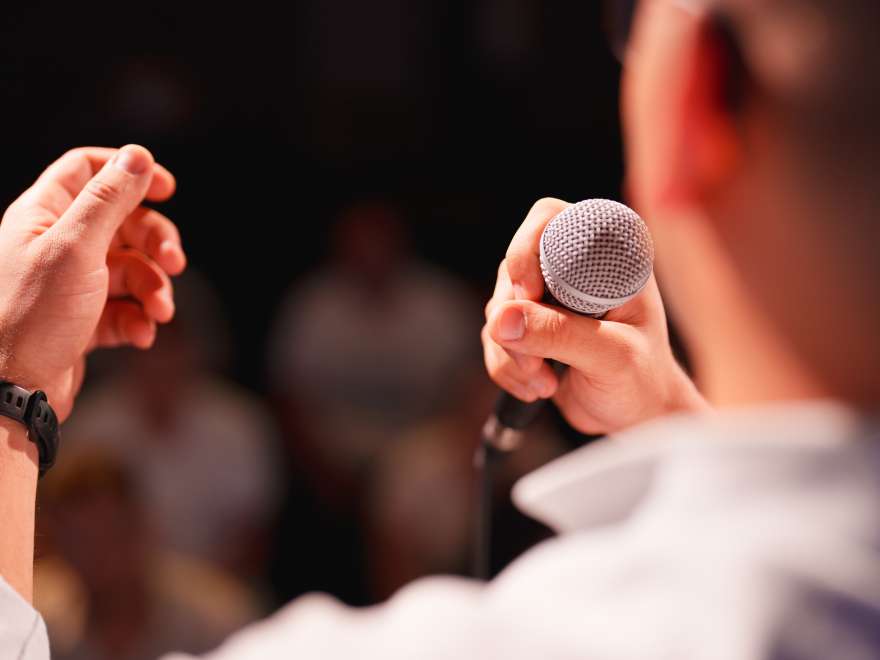 Conference speakers showing presentations on the stage