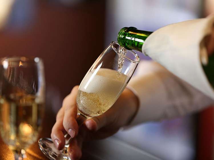 Barman pouring a glass of wine