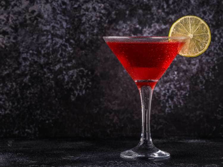 Cosmo cocktail in front of a velvet wall