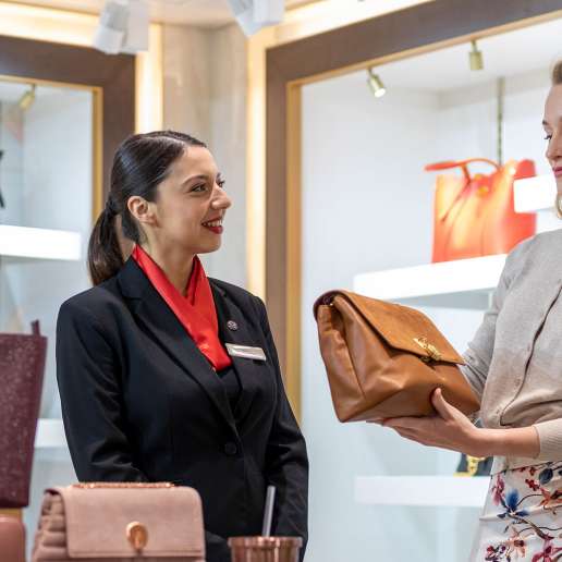 Sales assistant helping out passengers with a purchase on board a P&O Cruises shop