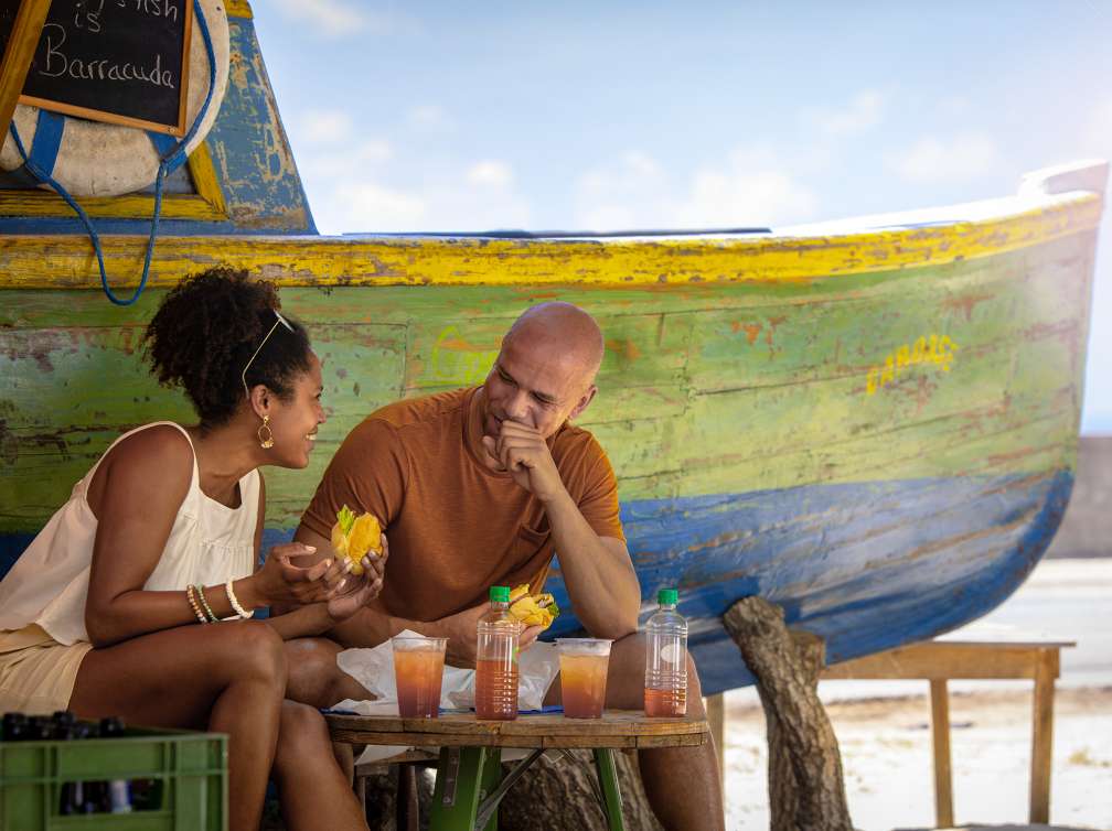 Couple enjoying drinks and food at a bar on a beach in Barbados