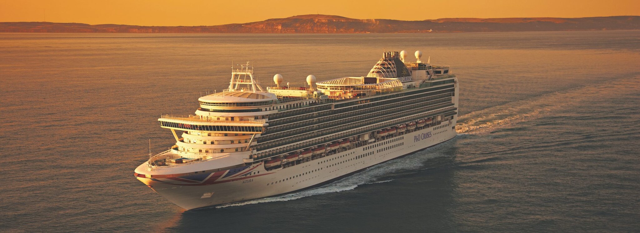 Azura P&O Cruises ship sailing at sunset from port bow