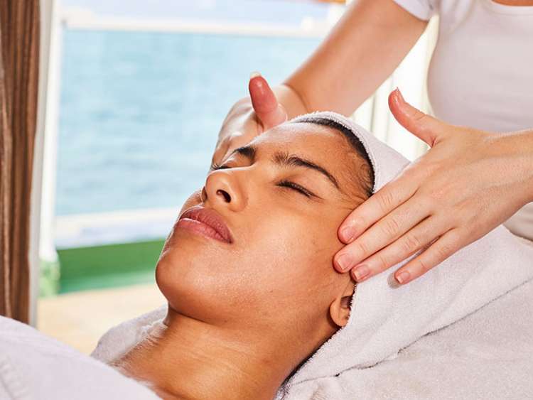Woman receiving temple massage at on-board spa