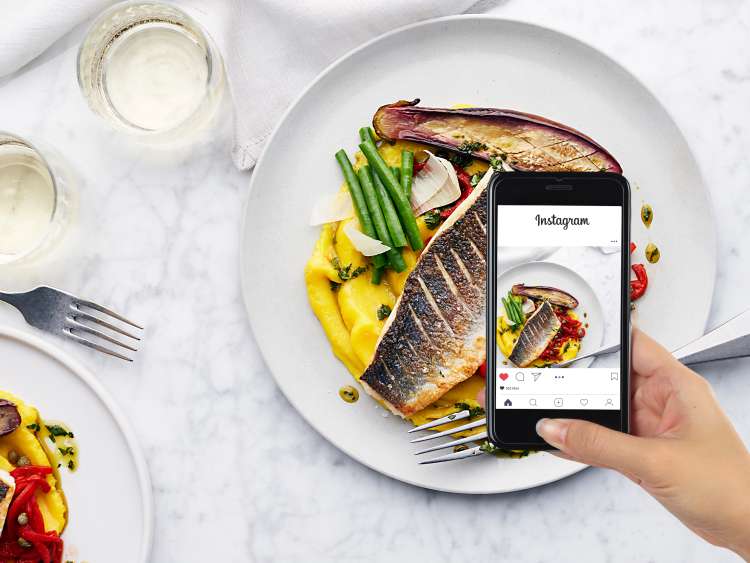 Person taking picture of their food to upload to Instagram 