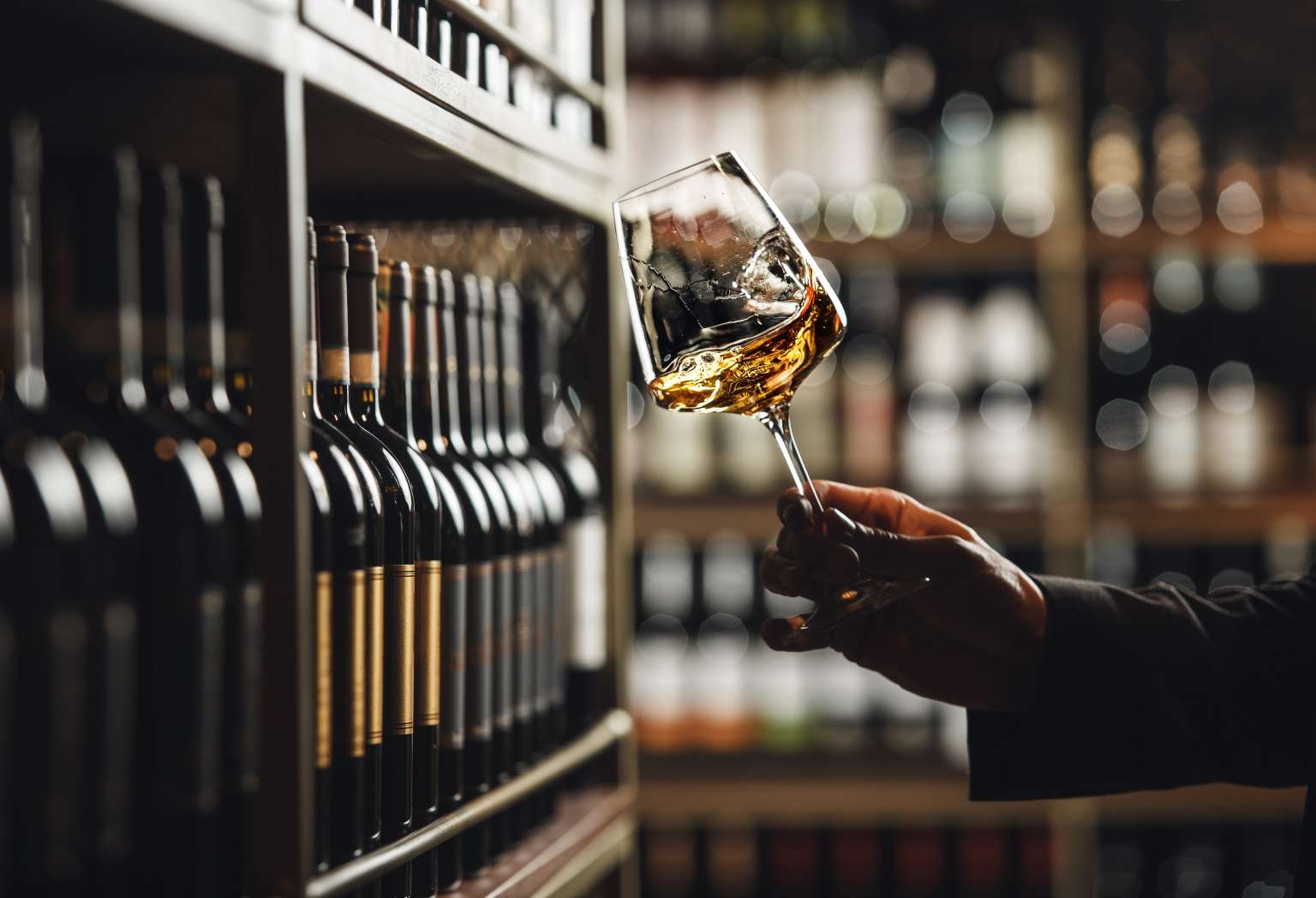 Close-Up of Sommelier Tasting White Wine in Dimly Lit Cellar