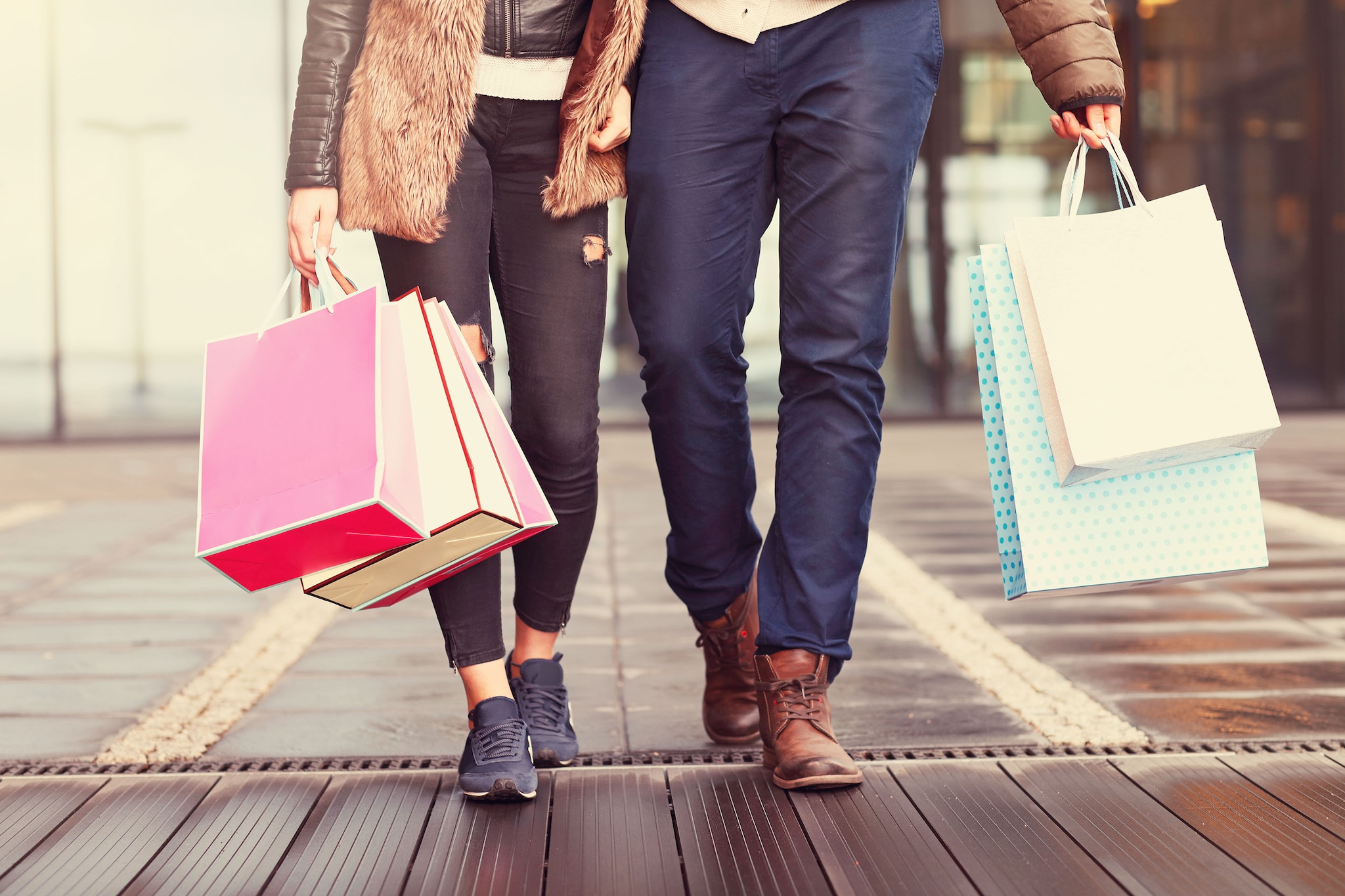 {"metadata_en_GB":{"alt-text":"Couple holding hands, carrying shopping bags"}}
