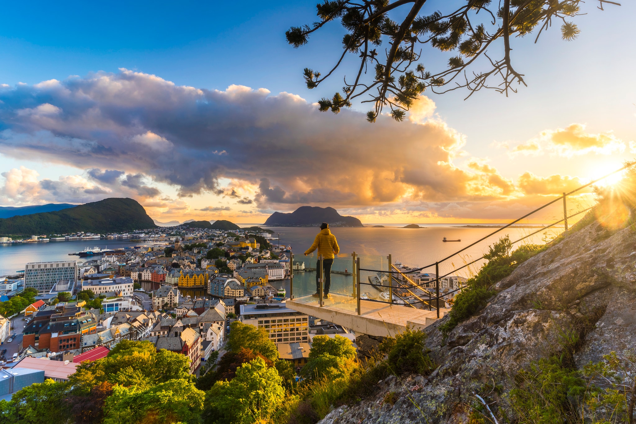 Man admiring the sunset over the city of Alesund from panoramic Byrampen viewpoint, More og Romsdal county, Norway