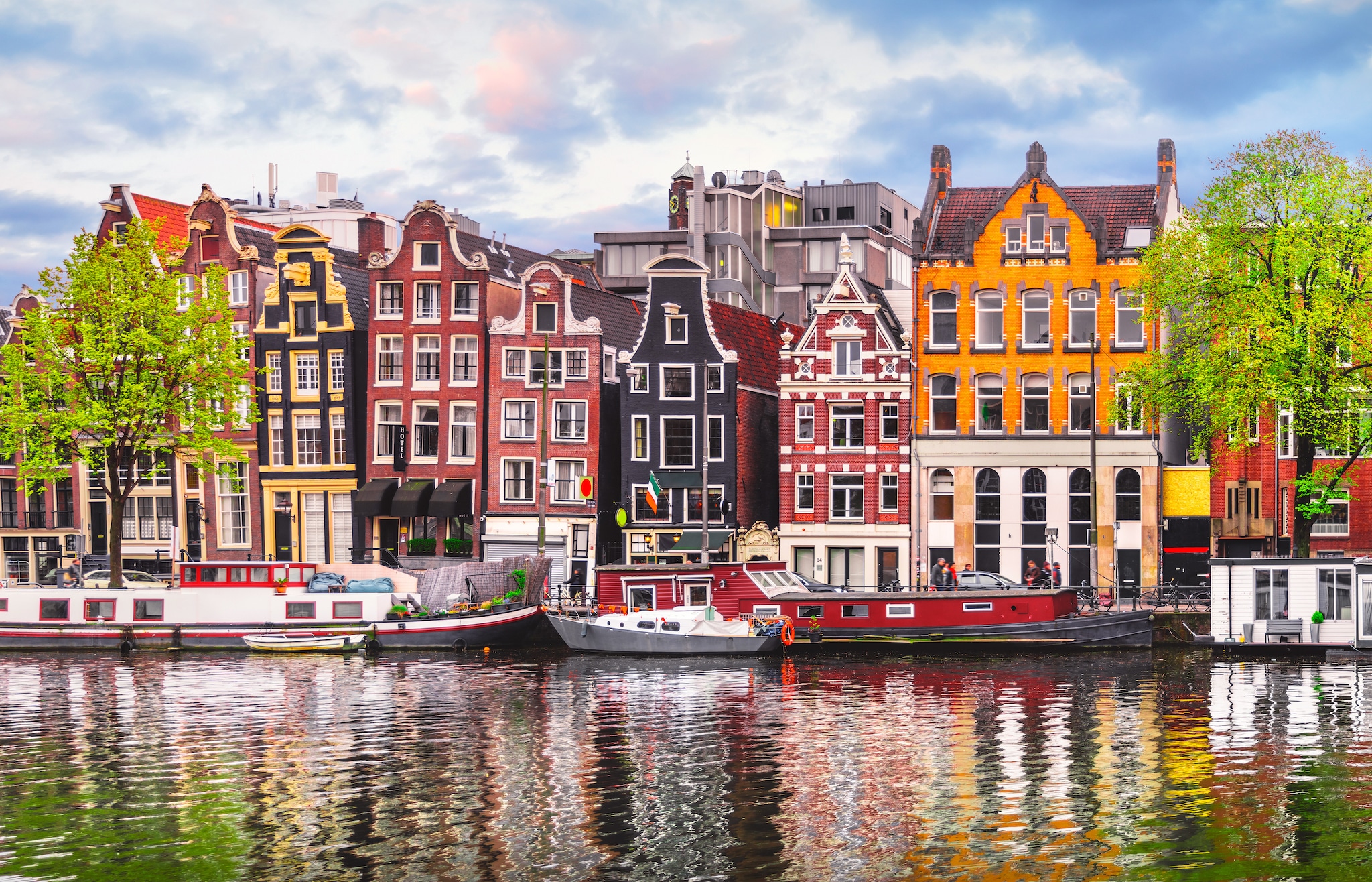Boats in Amsterdam canal in front of buildings