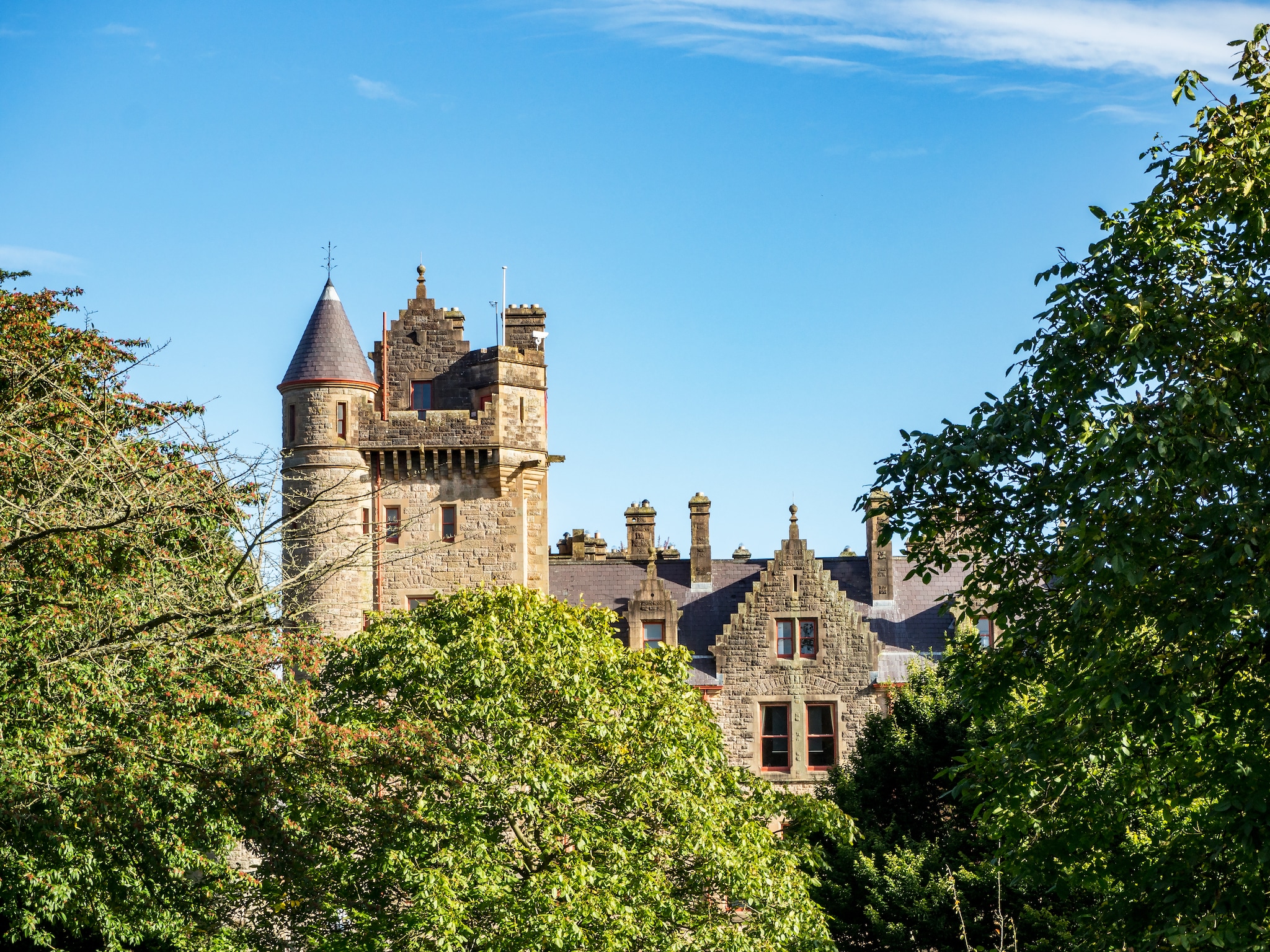 {"metadata_en_GB":{"alt-text":"The top of a castle surrounded by trees"},"metadata_en_AU":{"alt-text":"The top of a castle surrounded by trees"}}