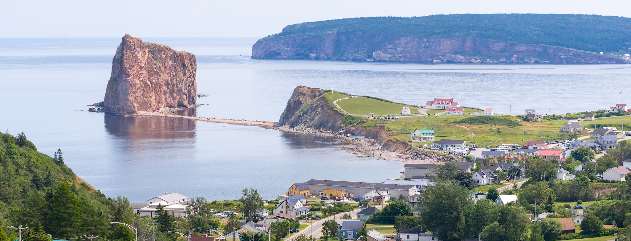 {"metadata_en_GB":{"alt-text":"A cliff next to water, a beach and houses"},"metadata_en_AU":{"alt-text":"A cliff next to water, a beach and houses"}}