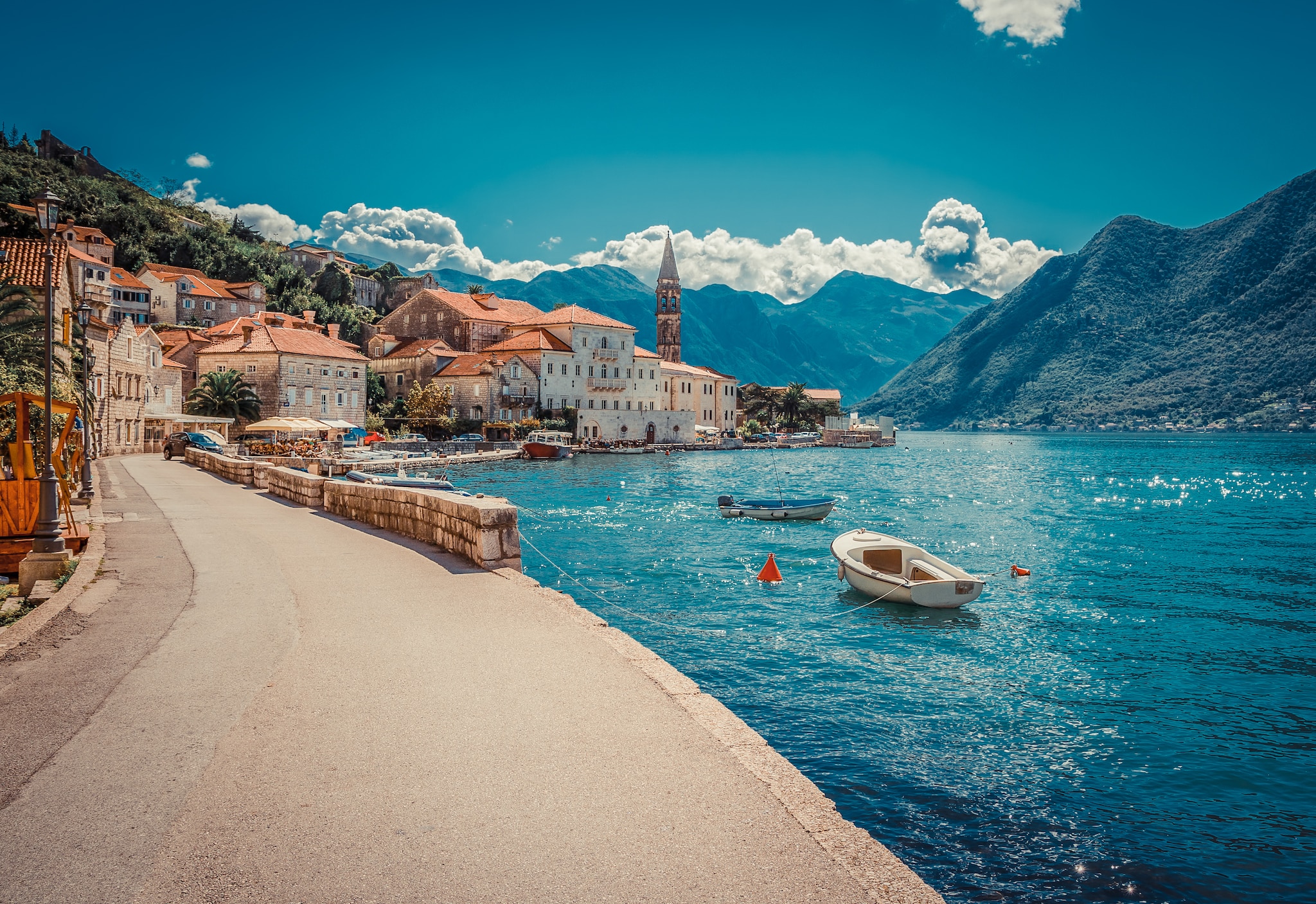 {"metadata_en_GB":{"alt-text":"Kotor Cruise Port, Montenegro, P&O Cruises Mediterranean Holiday Destination"},"metadata_en_AU":{"alt-text":"Image of path along coastline with sea to the right and a small village to the left."}}