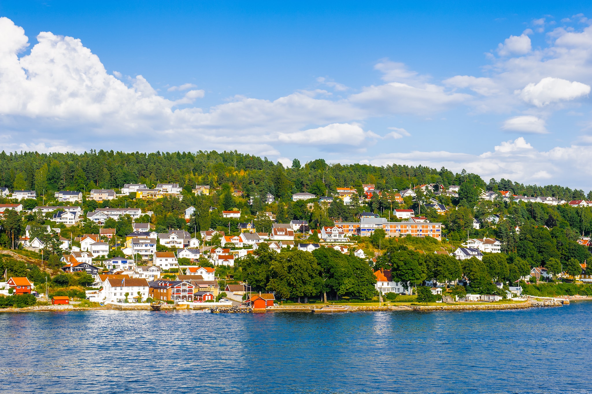 {"metadata_en_GB":{"alt-text":"A sky view of houses and trees behind water"},"metadata_en_AU":{"alt-text":"A sky view of houses and trees behind water"}}