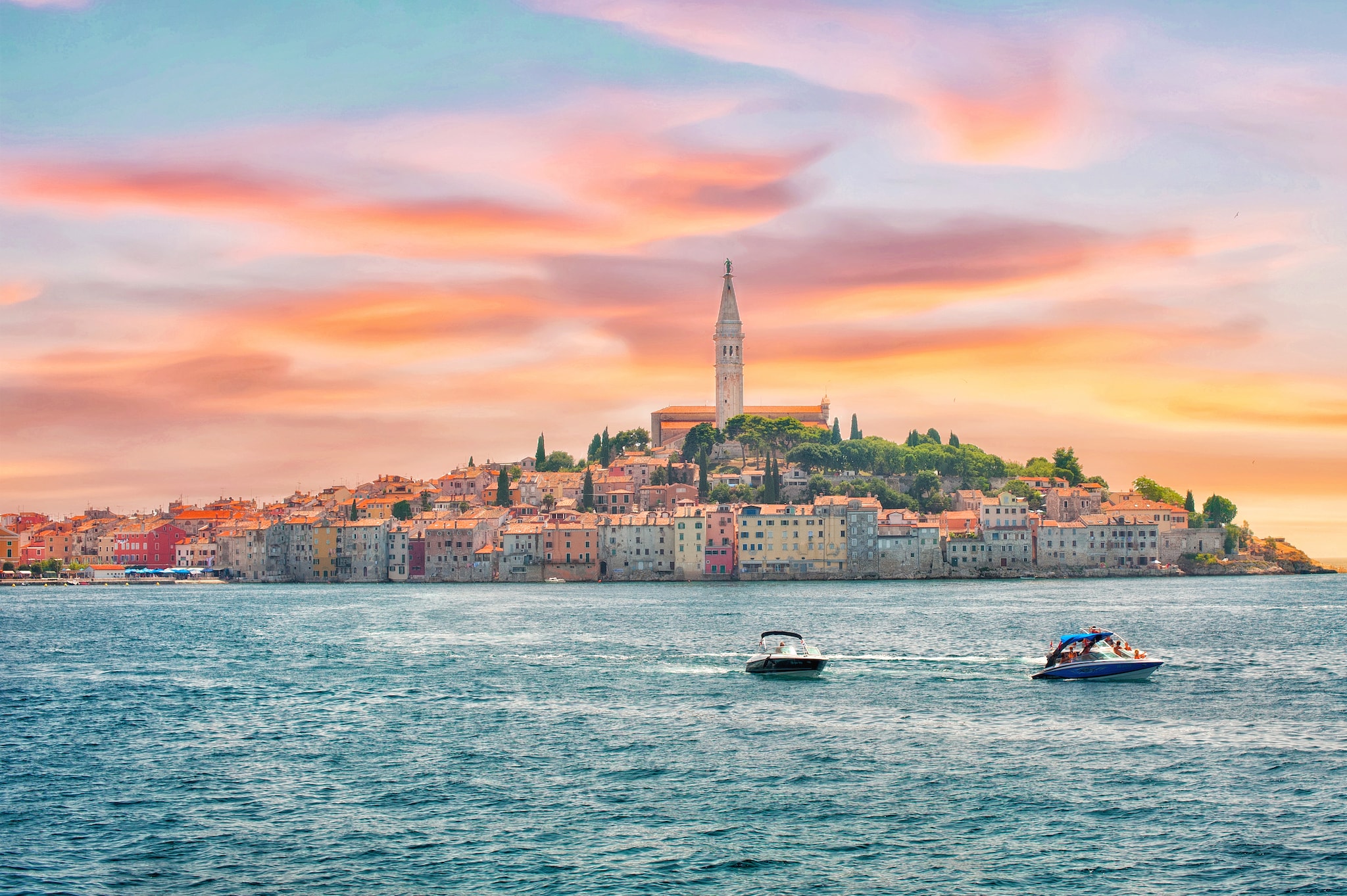 {"metadata_en_GB":{"alt-text":"Two speedboats in sea in front of town lit up by sunset"},"metadata_en_AU":{"alt-text":"Two speedboats in sea in front of town lit up by sunset"}}