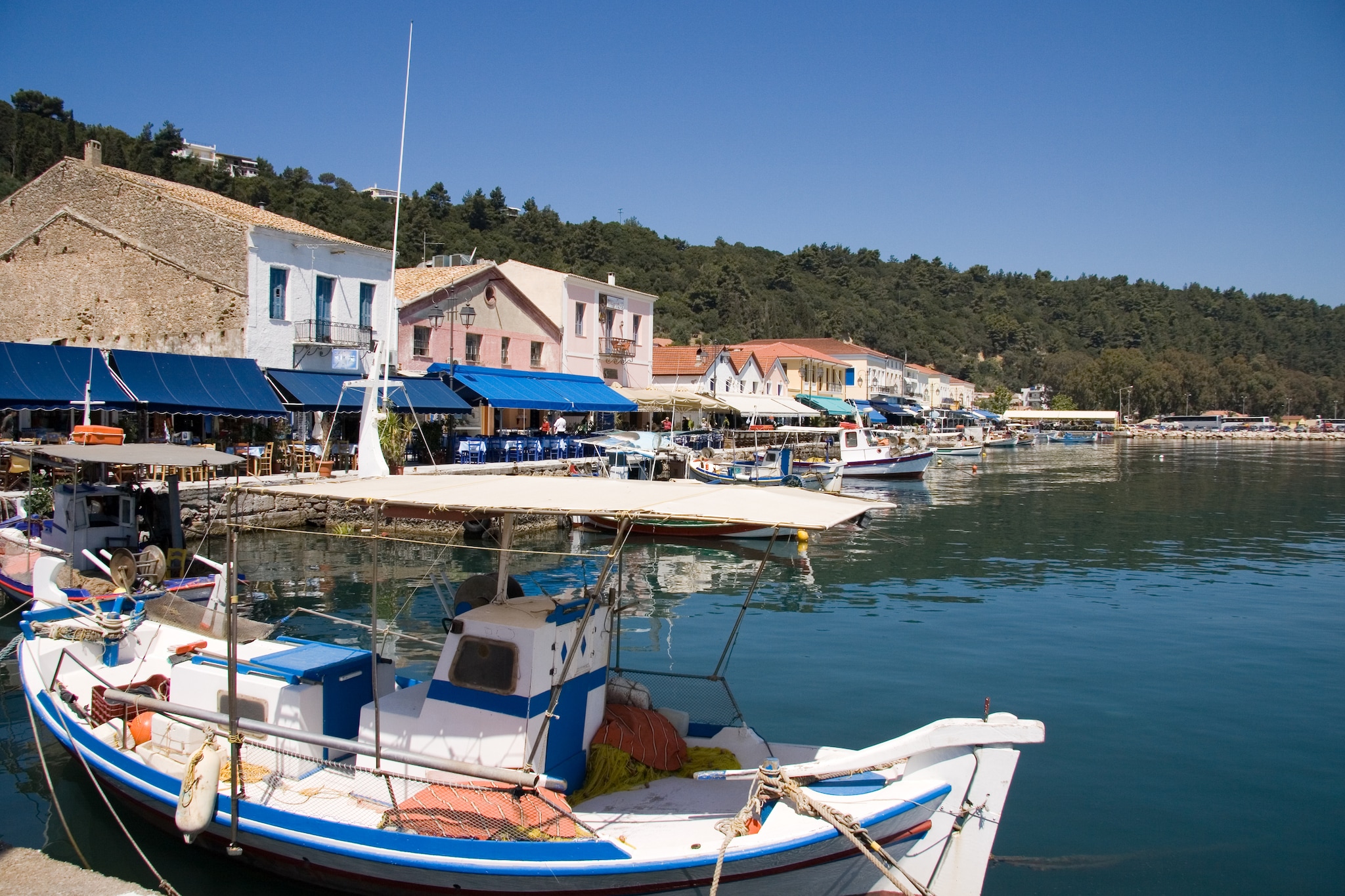 {"metadata_en_GB":{"alt-text":"Small Fishing Boat and view of Restaurant Row on the Harbor at Katakolon Greece"}}