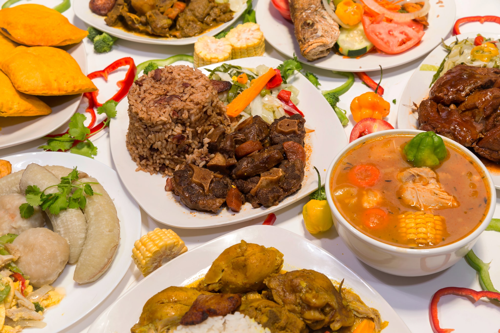 Traditional Jamaican cuisine including beef patties, jerk chicken, rice and brown stewed chicken