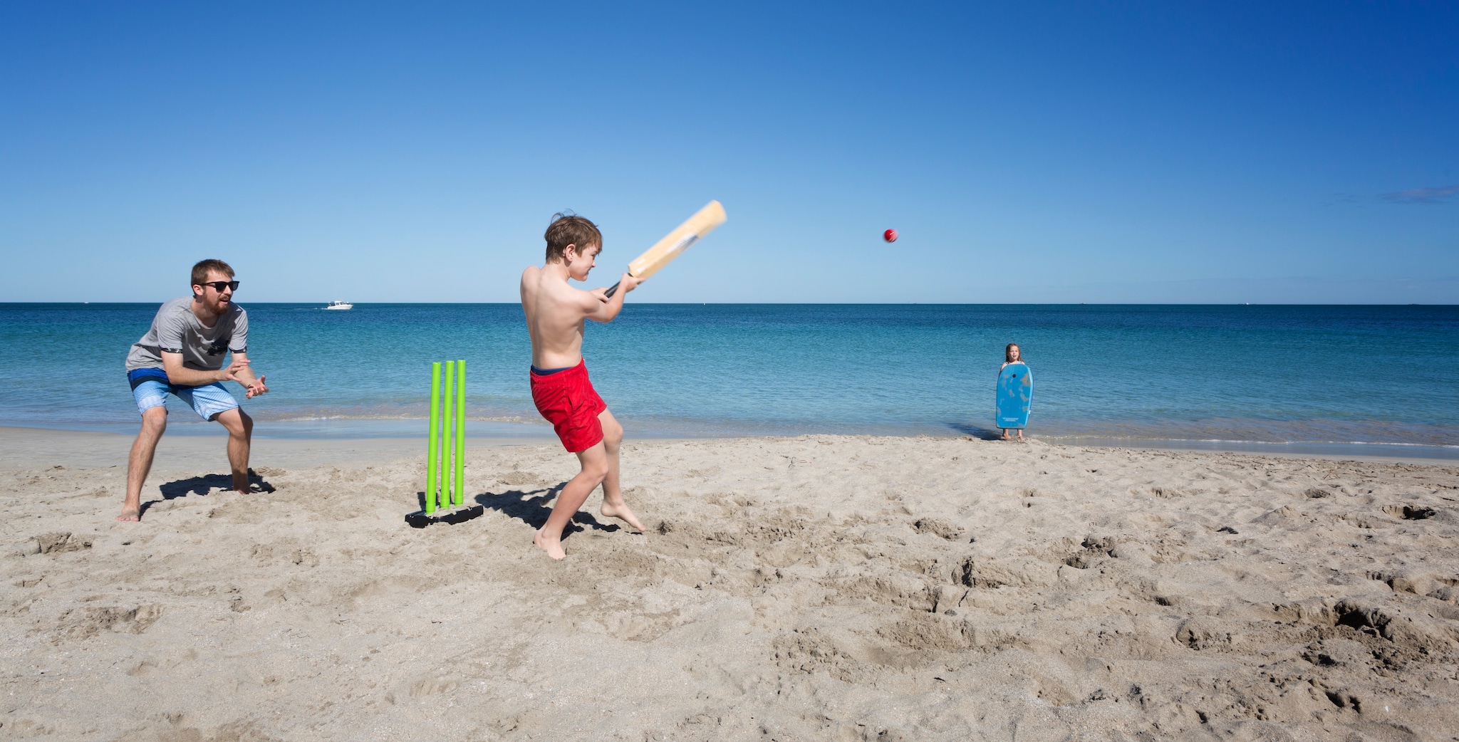 {"metadata_en_GB":{"alt-text":"Playing beach cricket, an Australian family tradition."}}