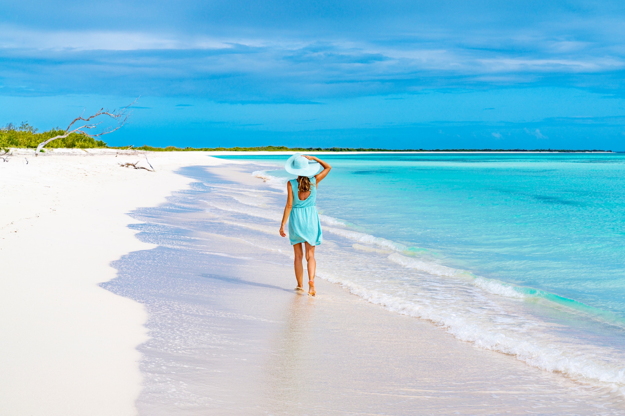 {"metadata_en_GB":{"alt-text":"Rear view of carefree woman in turquoise dress walking on a white sand beach, Barbuda, Antigua & Barbuda, Caribbean, West Indies"}}