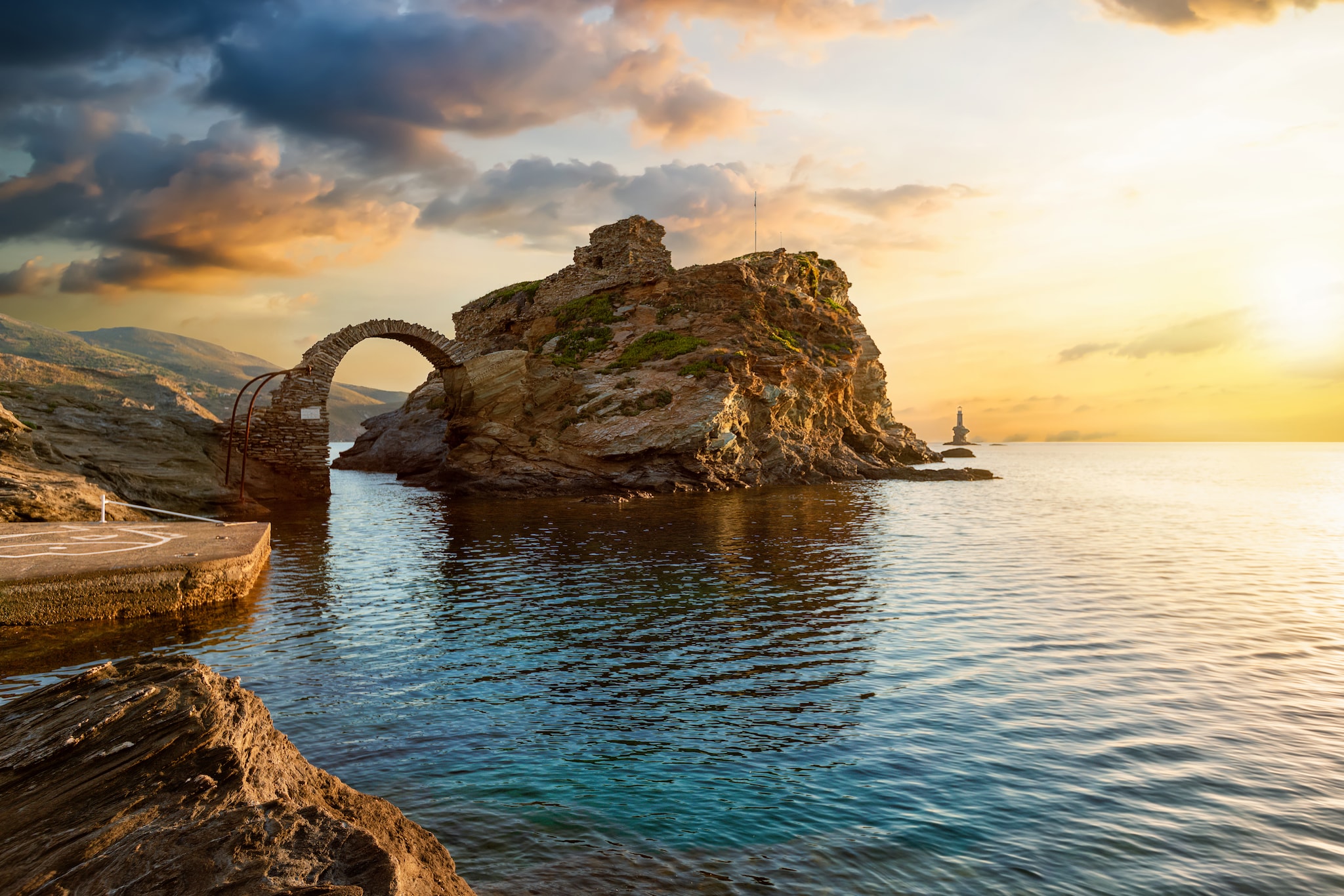 The old arched stone bridge leading to the ancient Castle of Andros island at the Cyclades of Greece during a beautiful summer sunrise; Shutterstock ID 1762659623; project: olly; job: ; client: pocruises; other: