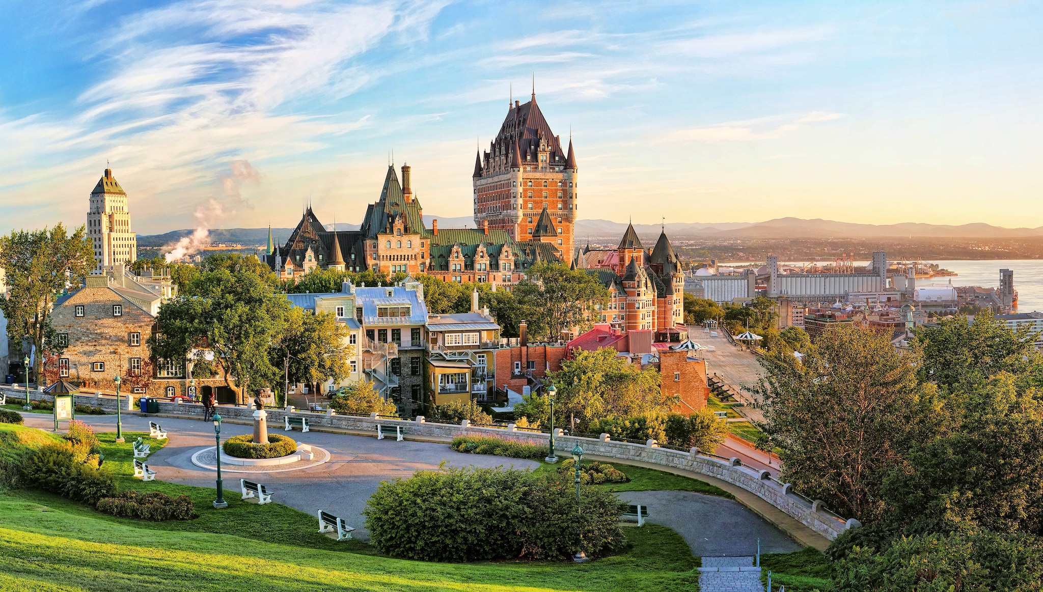 A panoramic view of Chateau Frontenac surrounded by greenery in Old Quebec, Canada at sunrise
