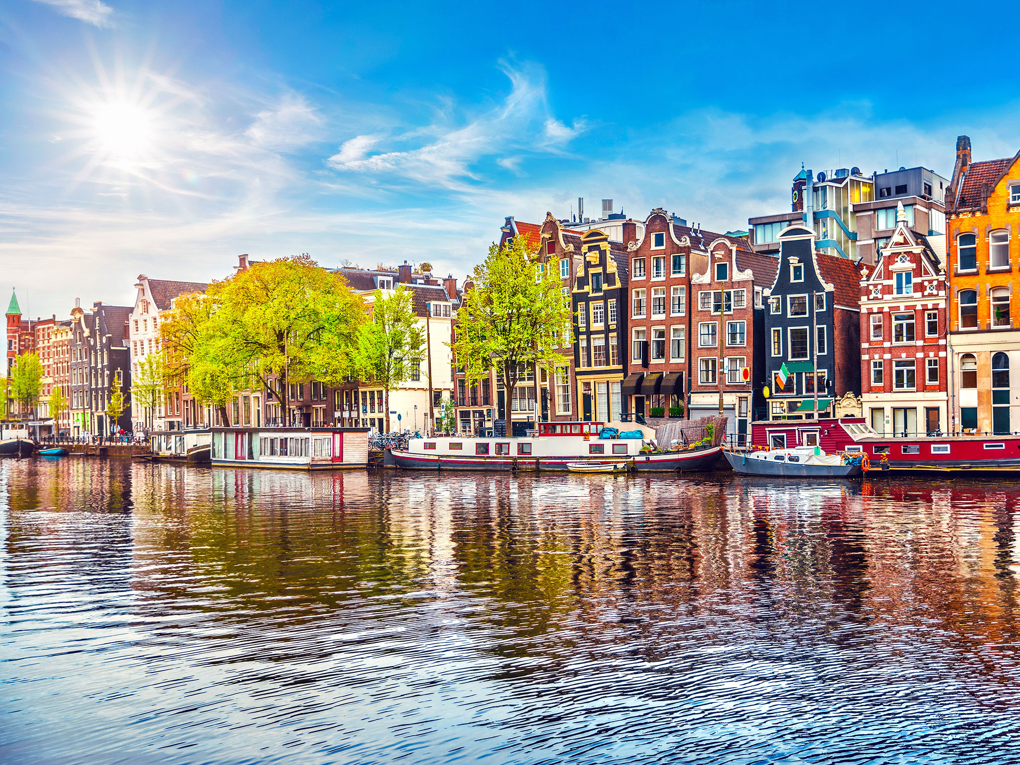 Barges and riverboats moored in canal in Amsterdam
