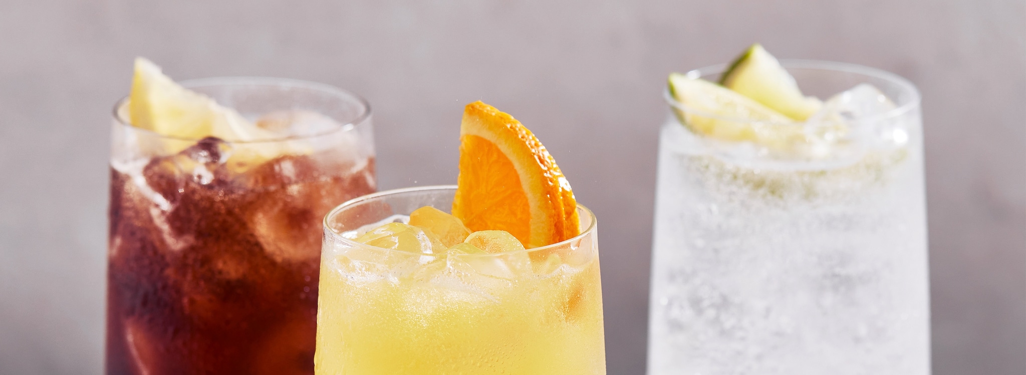 {"metadata_en_US":{"alt-text":"3 glasses of different soft drinks and a wedge of fruit in each"}}