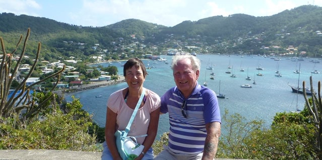 Couple sat smiling together with harbour in the background in Guadeloupe