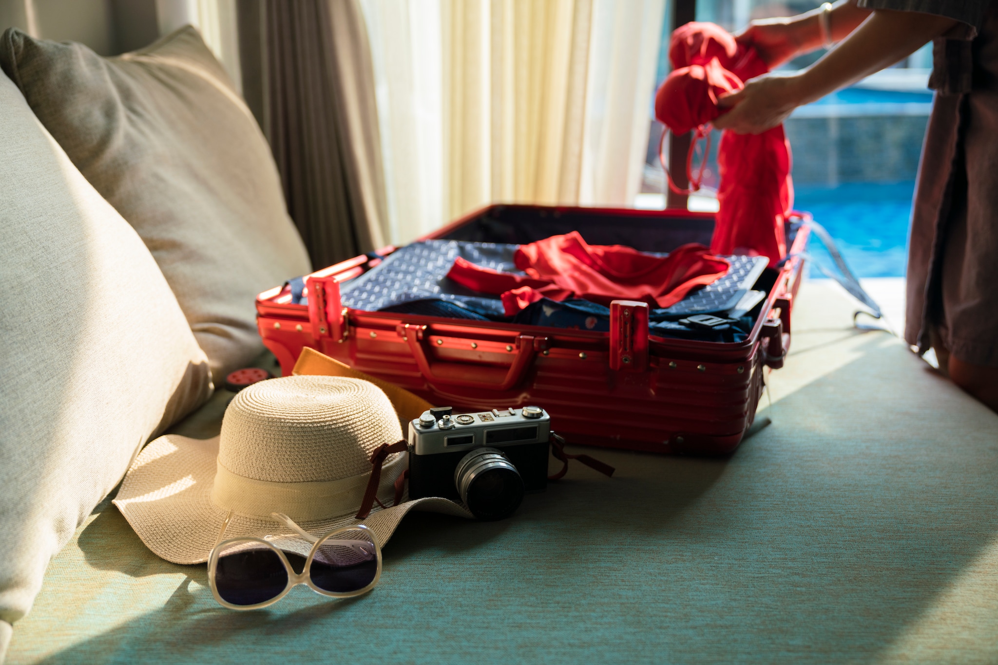 woman packing suitcase for summer trip.