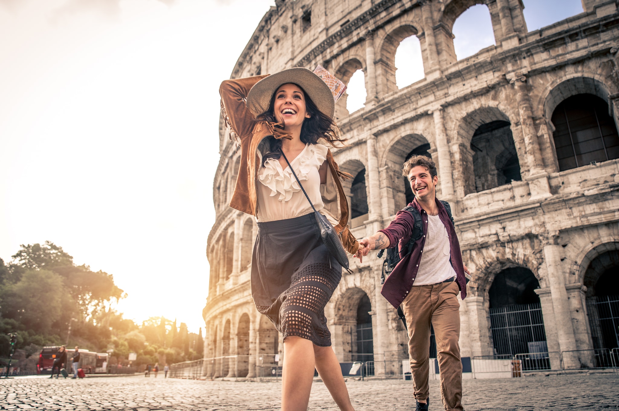 Young couple at the Colosseum, Rome - Happy tourists visiting Italian famous landmarks