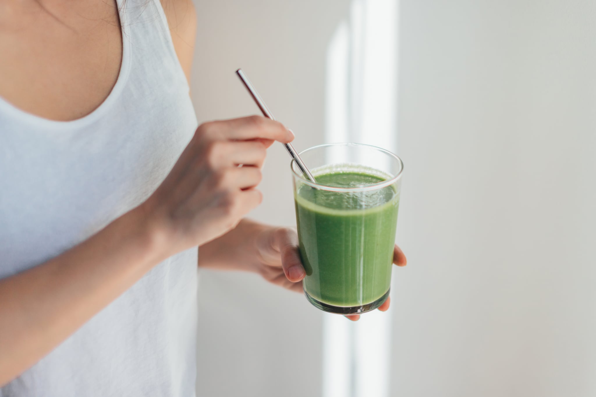 {"metadata_en_GB":{"alt-text":"Cropped shot of young woman drinking vegan smoothie with metal straw."}}