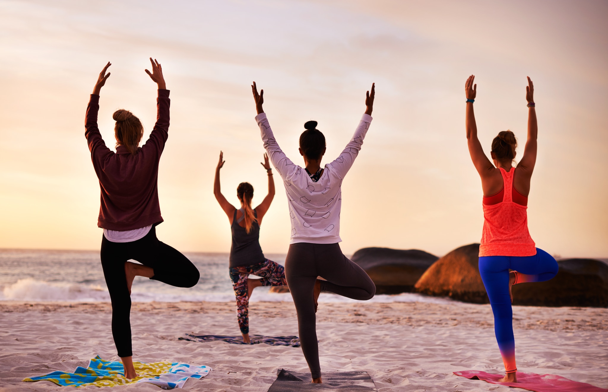 Shot of a group of people having a yoga session on the beach